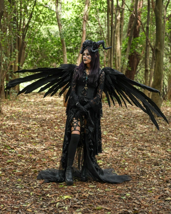 a woman wearing black clothing with large wings