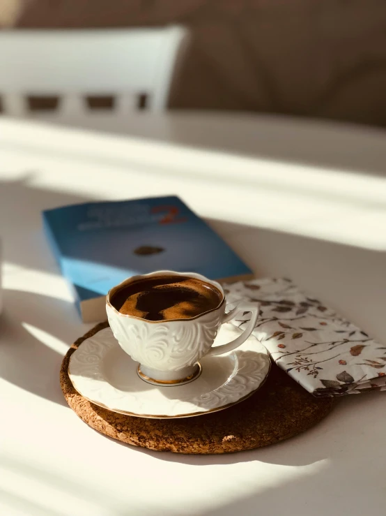 an empty cup with saucer and saucer sitting on a coaster