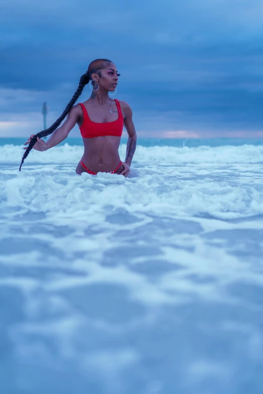 a woman in a bikini stands in the water