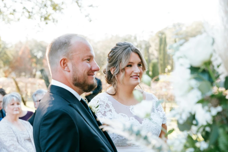 two people sitting at a wedding ceremony looking back