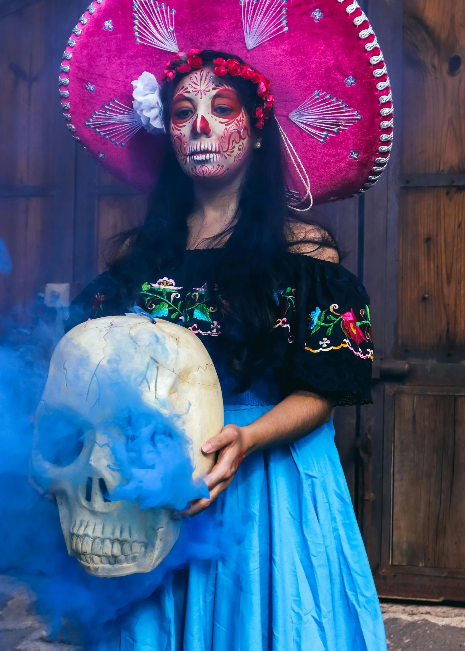 a person in mexican attire holding a skull