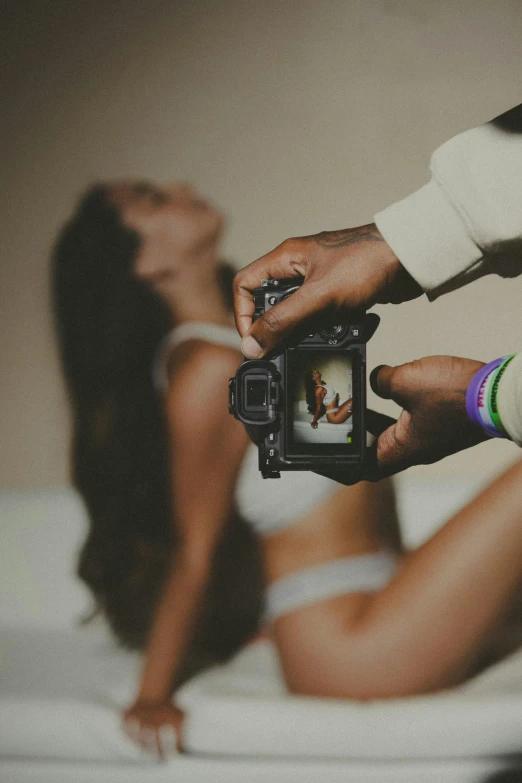 a woman in a white bikini holds a camera