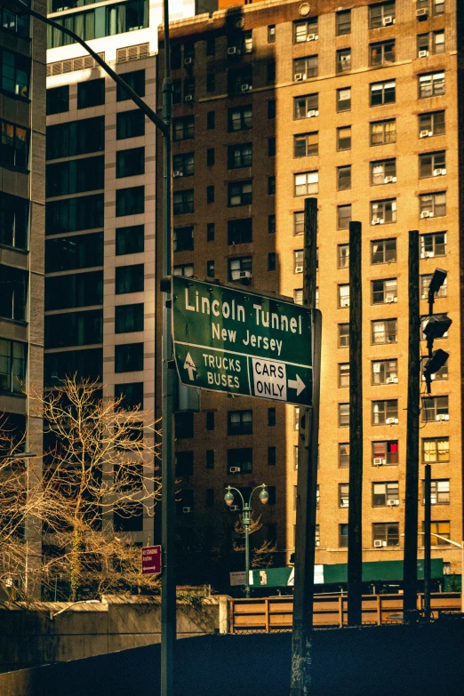 a street pole with many street signs near large buildings