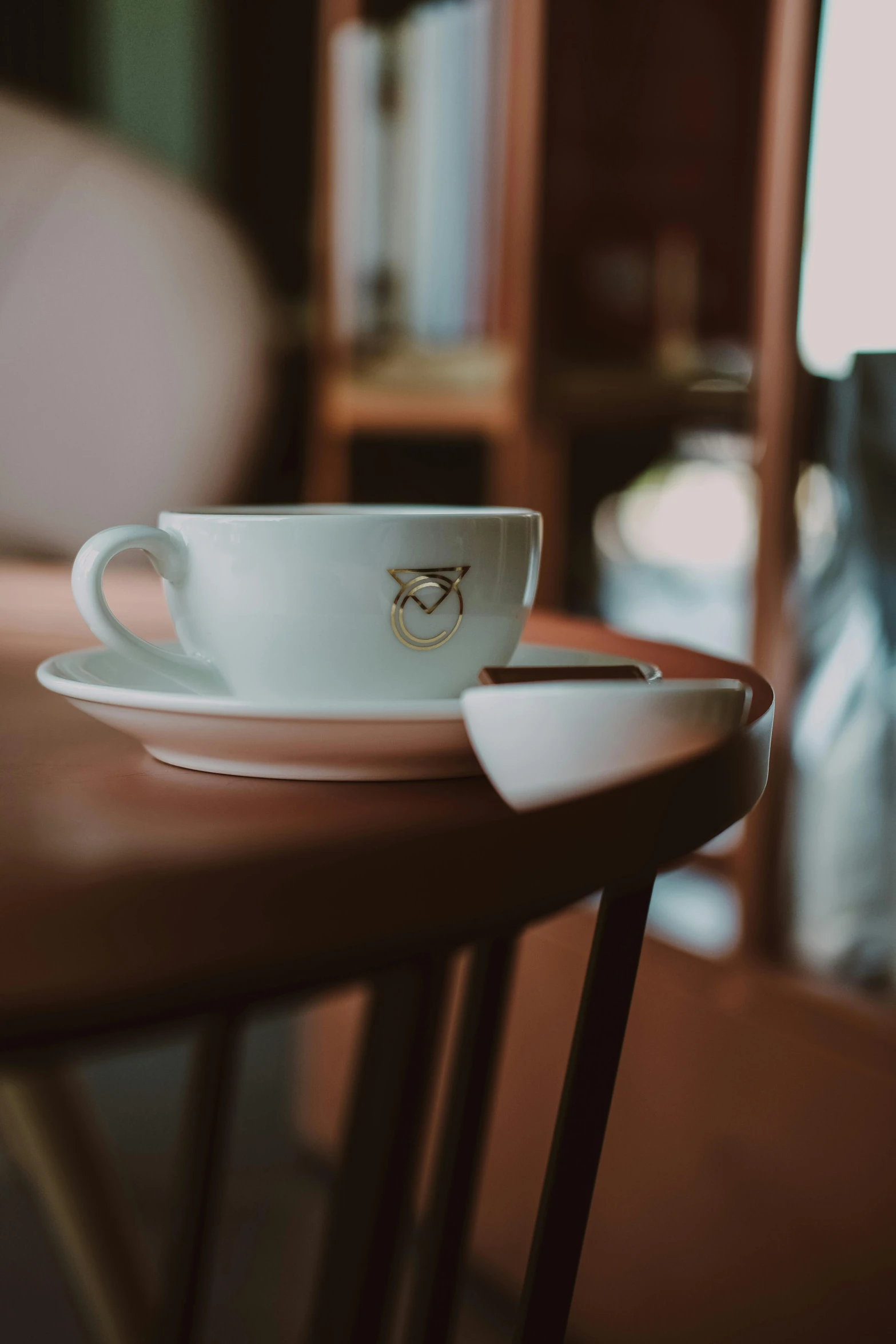 an empty cup on a saucer that is sitting on a table