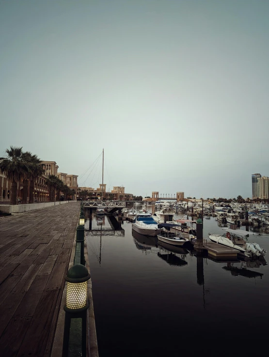 a marina with several boats on it and buildings in the background