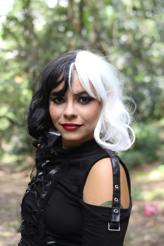 a very short girl wearing a black top and some trees