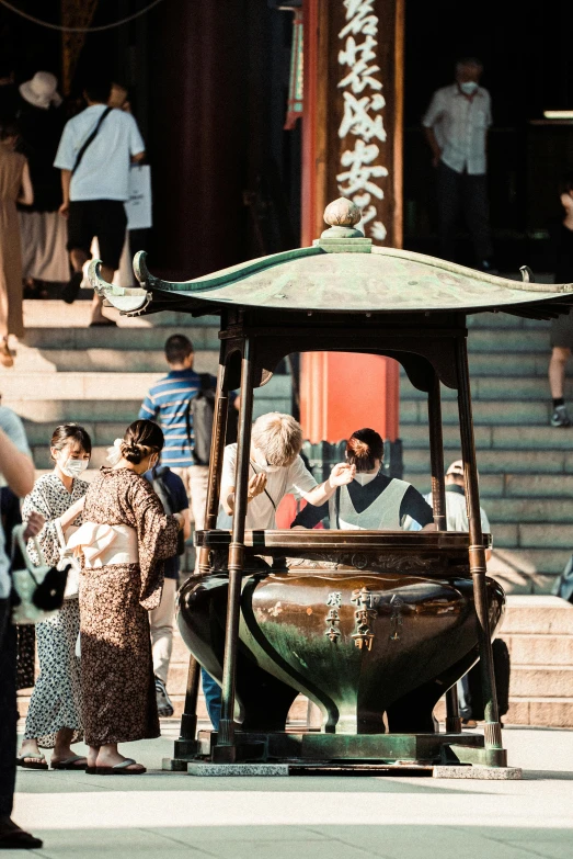 people are standing around in front of a chinese gazebo