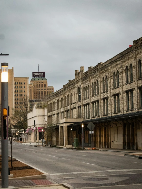 a very wide city street with the street lights still on