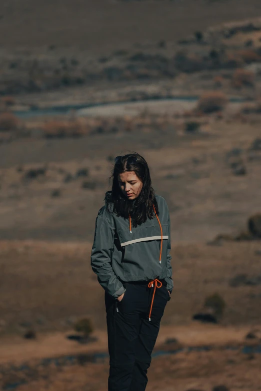 a woman is standing with her hands on her hips in the desert