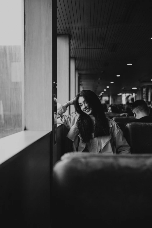 black and white image of a lady sitting on a train