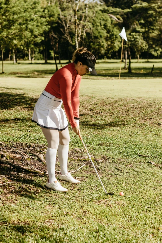 a person putting a golf ball in a tee