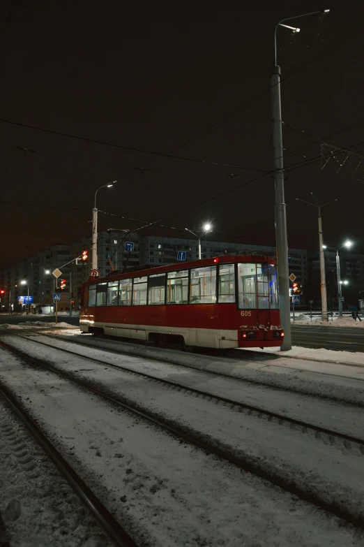 a trolley car is travelling through the snowy road