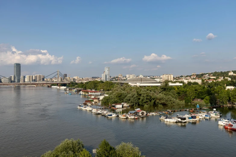 a river filled with lots of boats next to tall buildings