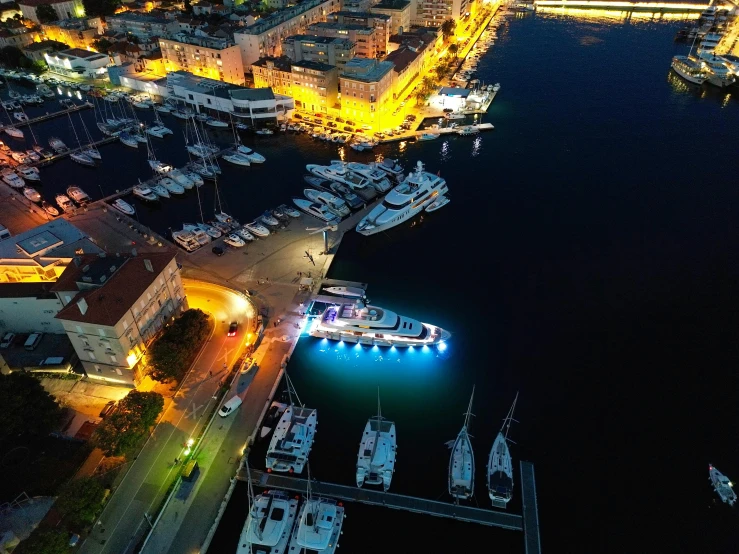 the night time view of boats docked on a dock in the city