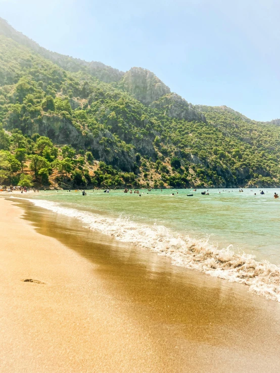 an image of beach scene with people swimming and playing