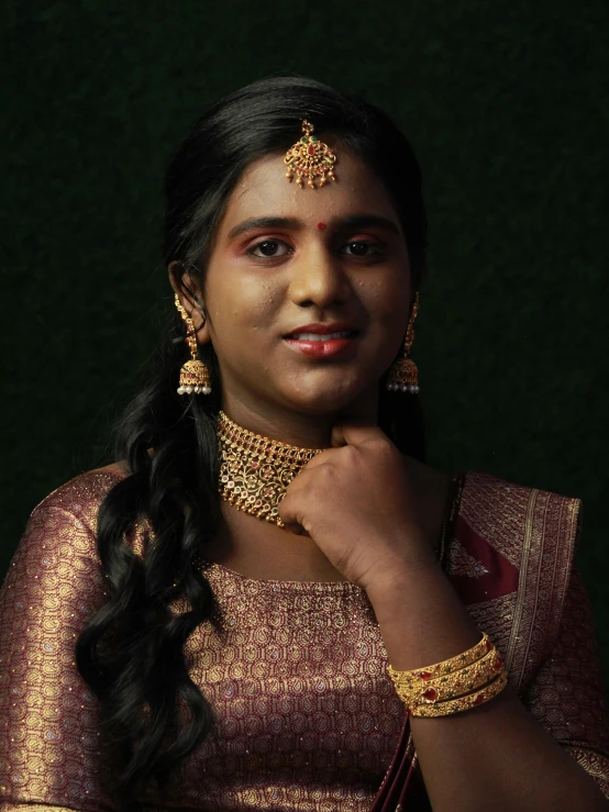 a girl wearing a gold colored outfit with intricate jewelry