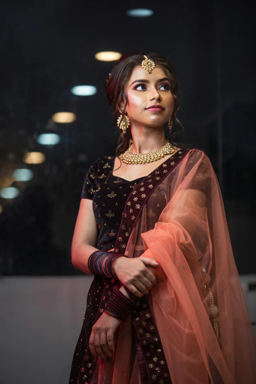 a model dressed in indian attire looks off to the side