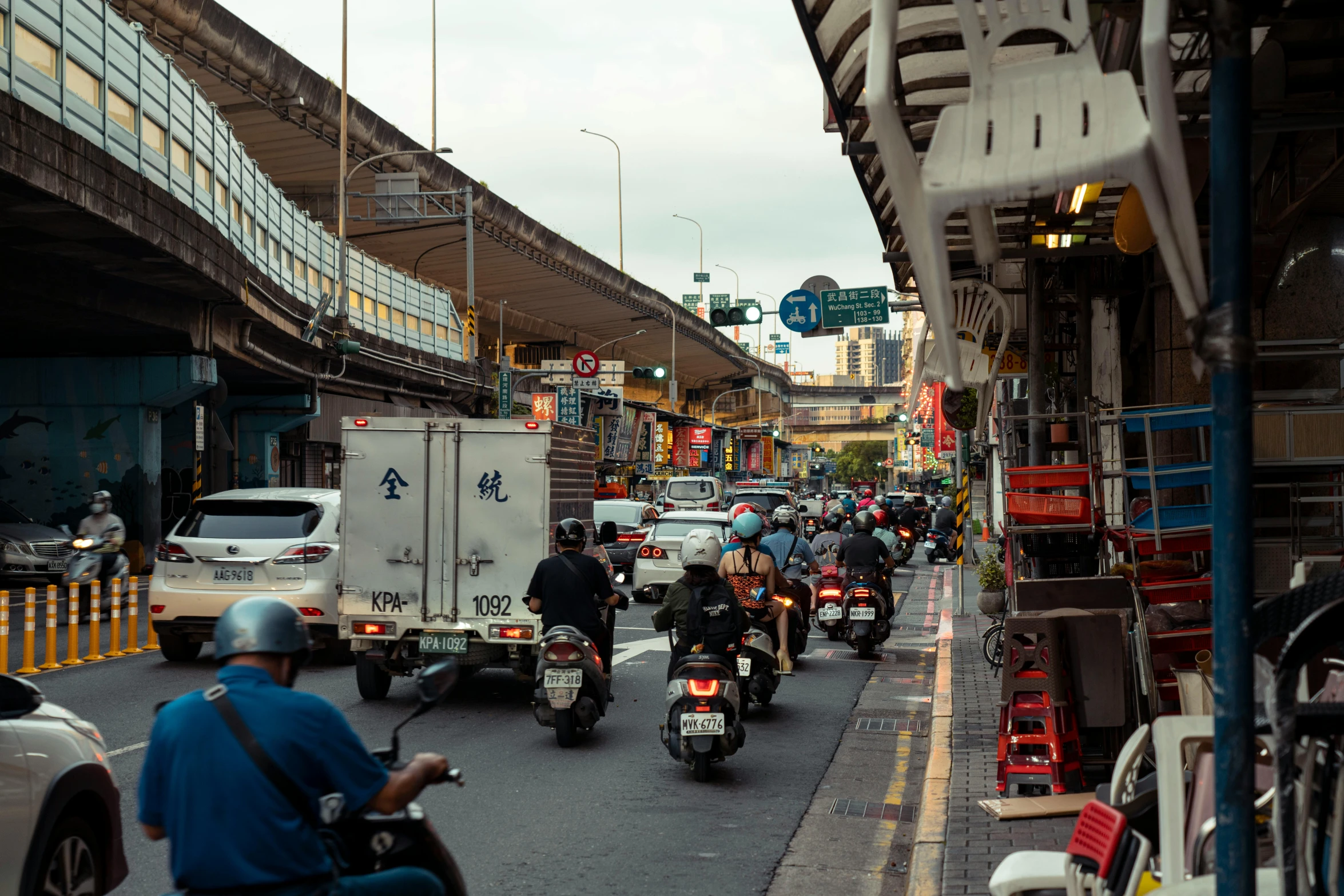 lots of people riding motorcycles on the street in the city