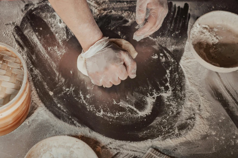 someone standing over a pan with dough on it