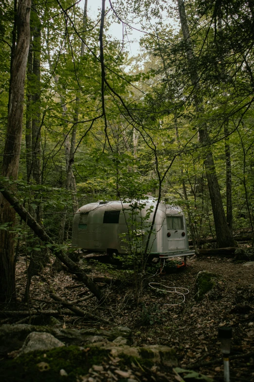 a caravan in the middle of a forest setting