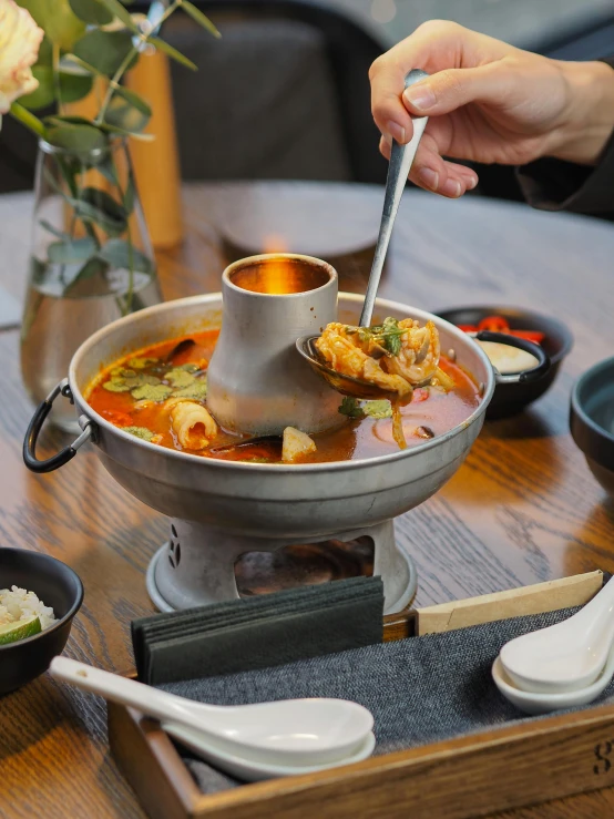 a person with chopsticks in a bowl filled with soup