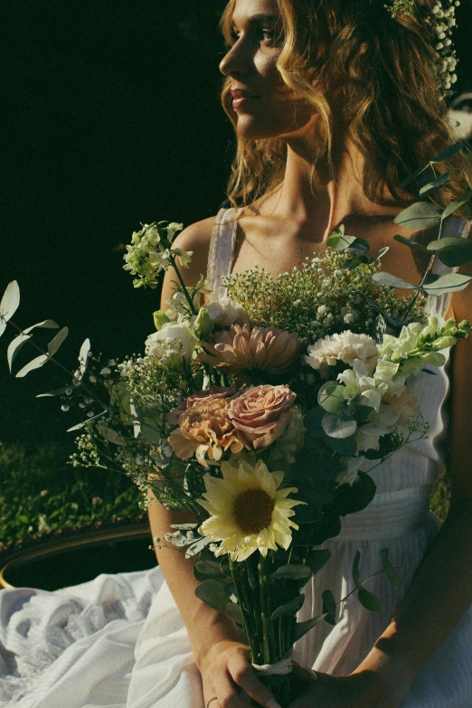 a young woman holding flowers by her side