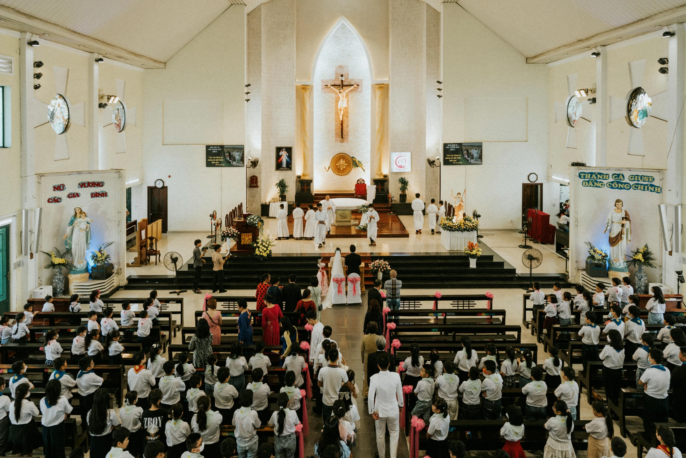 an aerial view of a small church with a choir of people