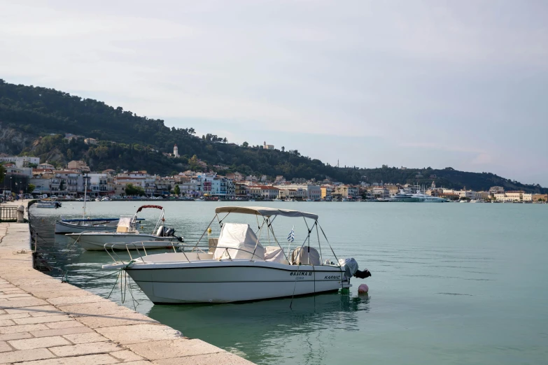 two boats tied up in the water at a pier