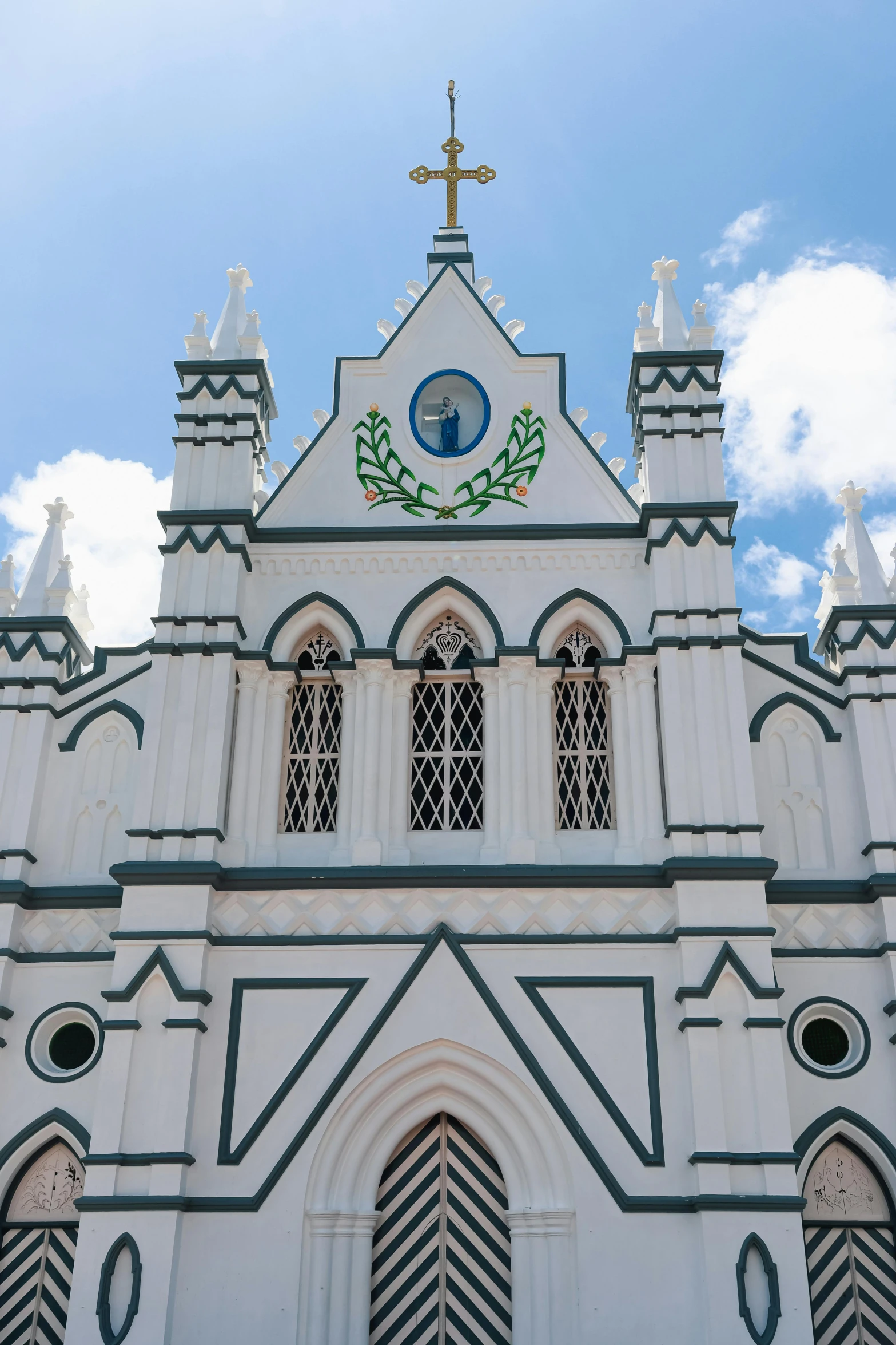 a tall white church has ornate design on its steeple