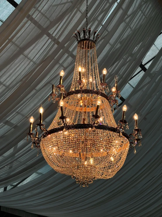 a chandelier hangs from a ceiling made with netting