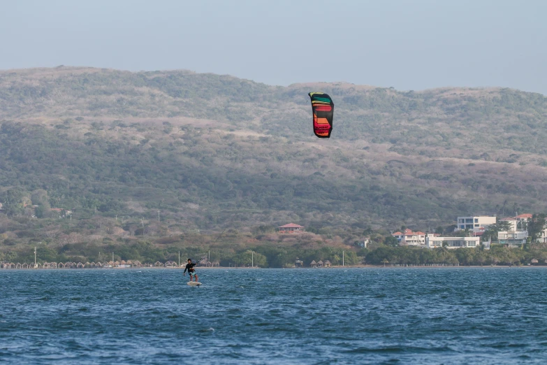 a kite boarder glides over a body of water