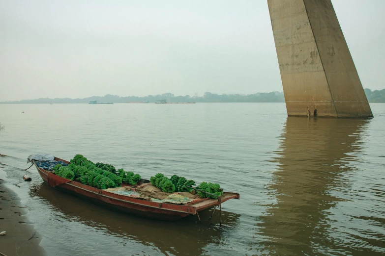 a boat is anchored in shallow water near a bridge