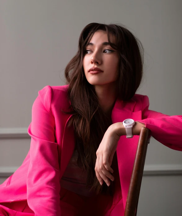 a woman sitting in a chair next to a wall