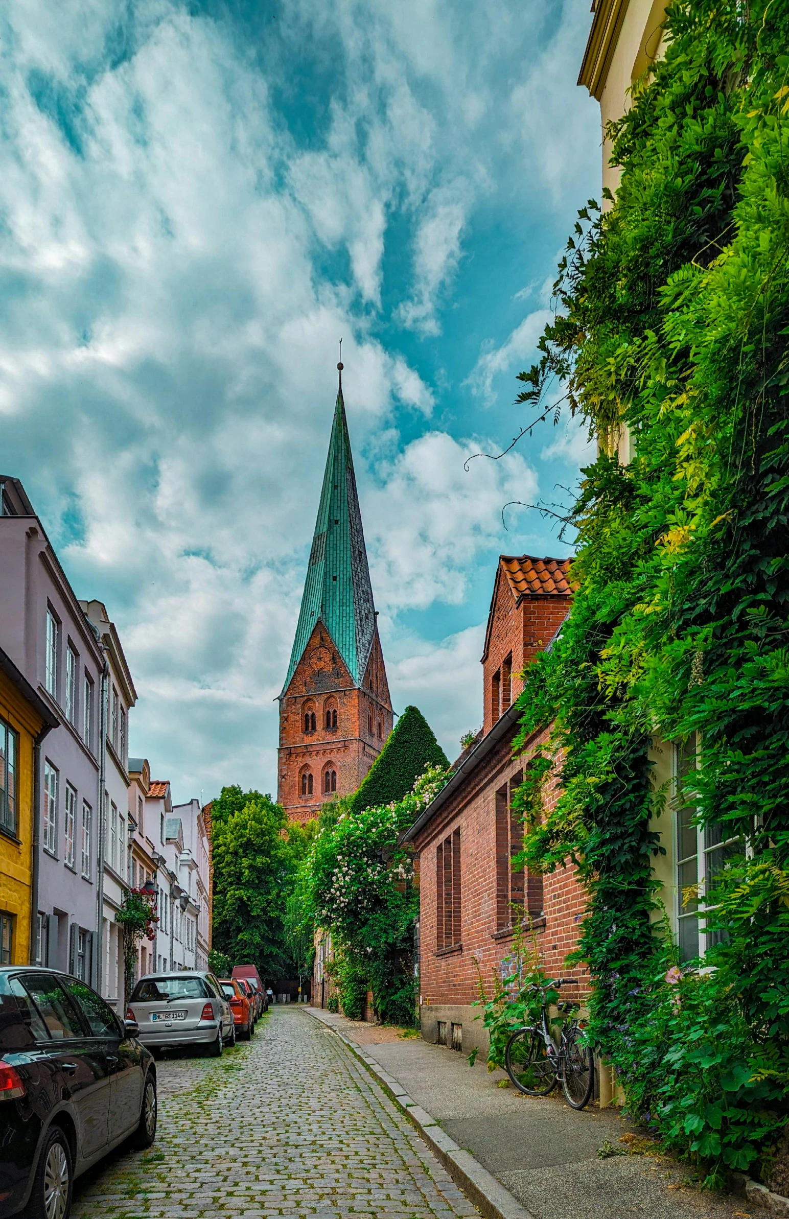 an old cobbled road lined with parked cars