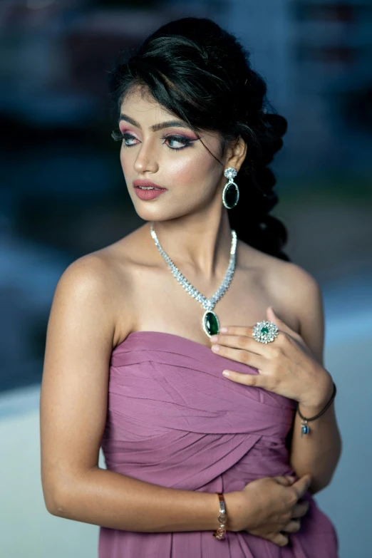 woman in an evening dress wearing a diamond and emerald necklace
