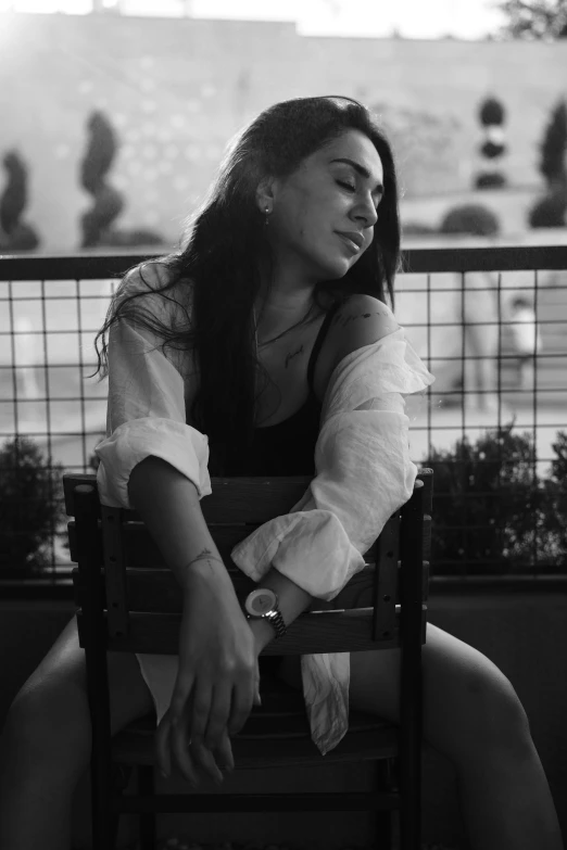 a young lady sitting in a chair at an outdoor restaurant