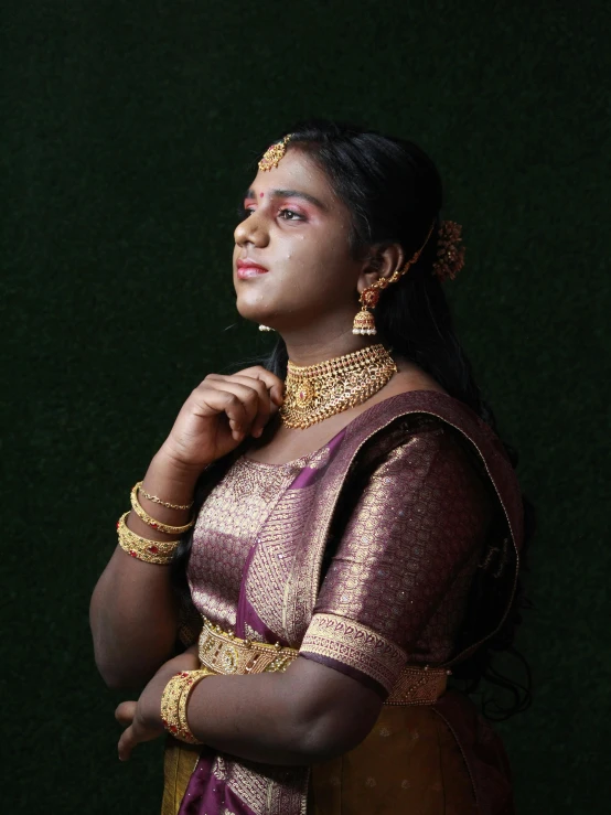 a woman with a necklace is dressed in a traditional indian outfit