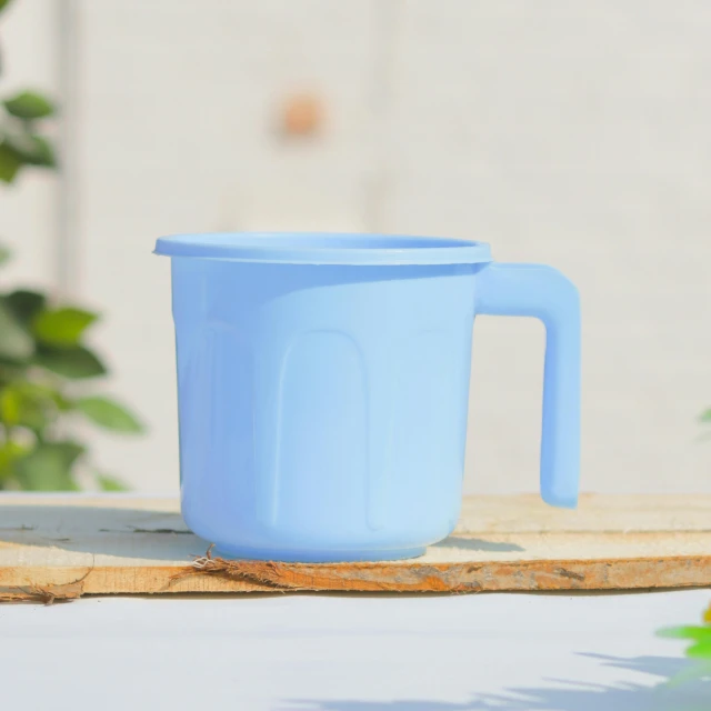 blue cup sitting on a wooden table outside