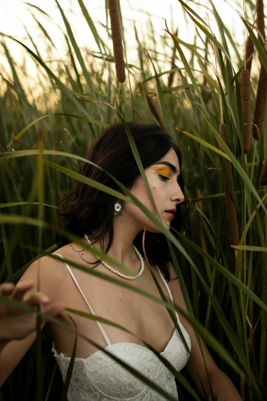 the lady is posing amongst the tall plants