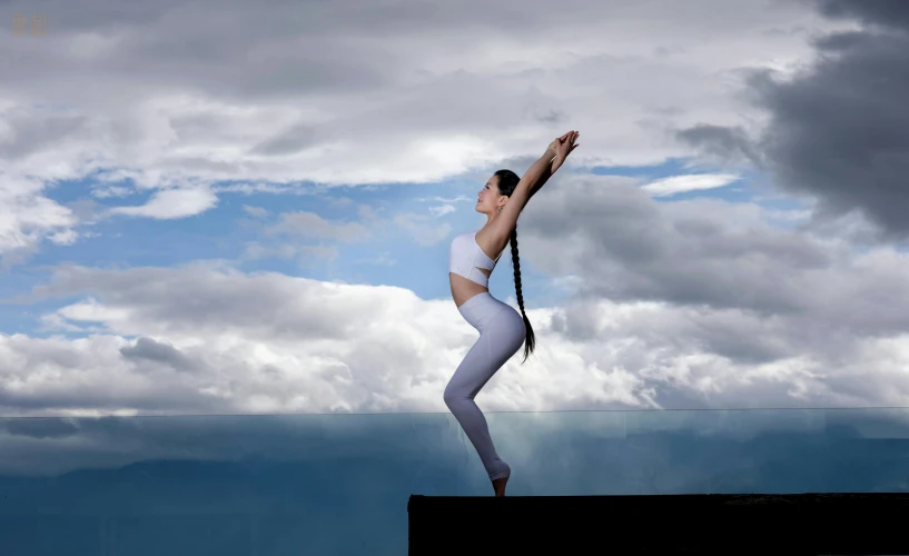 a girl in a white bodysuit is performing a ballet move