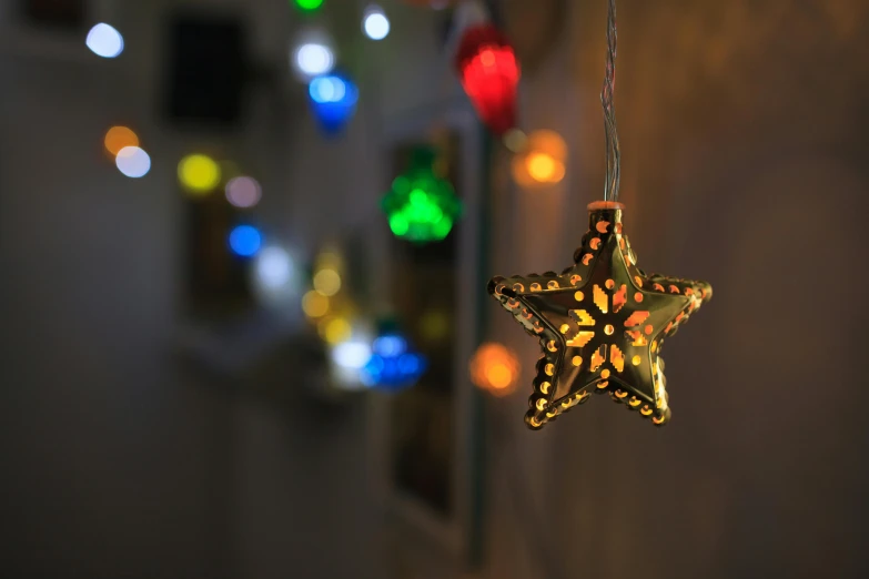 a close up view of a star ornament with multi - colored lights in the background