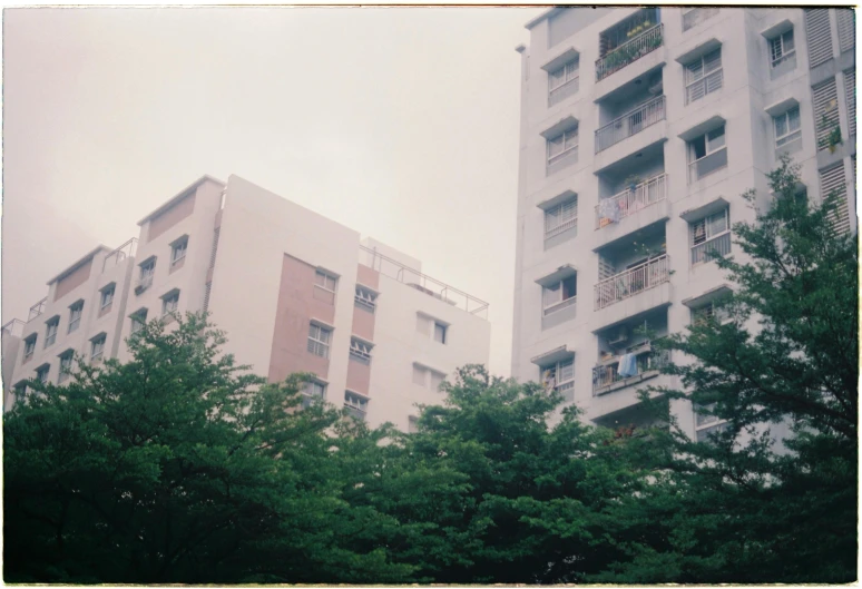 an apartment building surrounded by trees with people in the windows