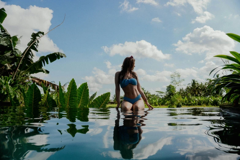 a woman in a blue bikini is sitting in the water