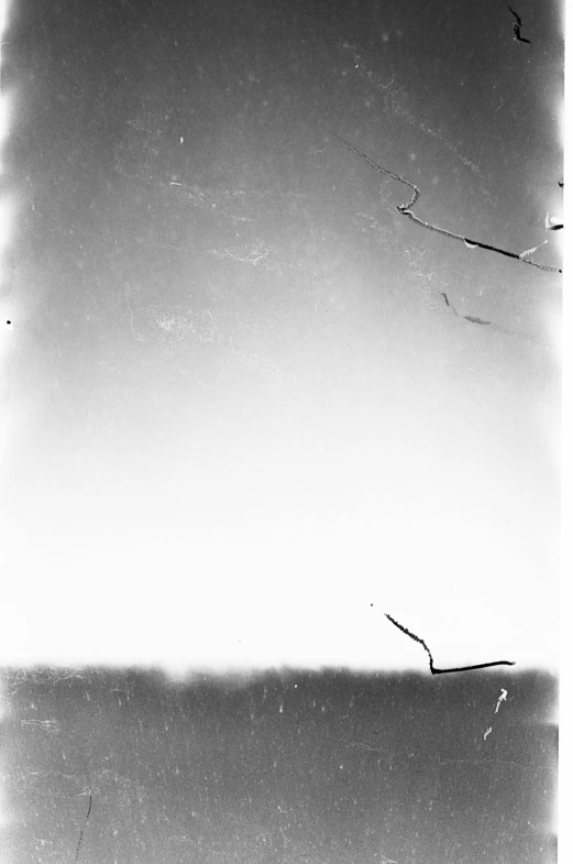 a kite flying in the sky with an ocean in the background