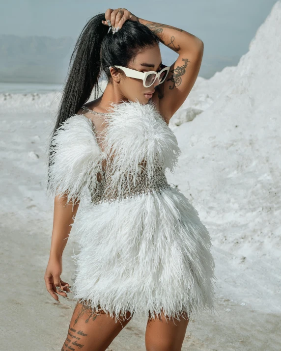 a woman with sunglasses and feather on posing for the camera