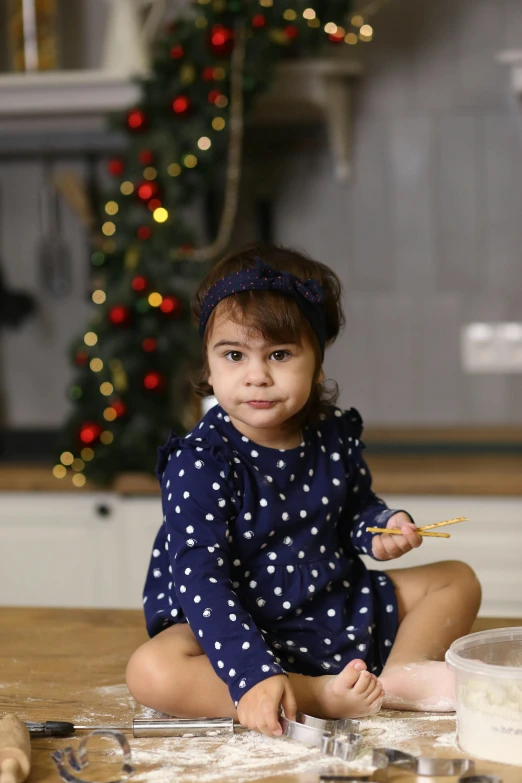 a little girl sitting on the floor with various food items around her