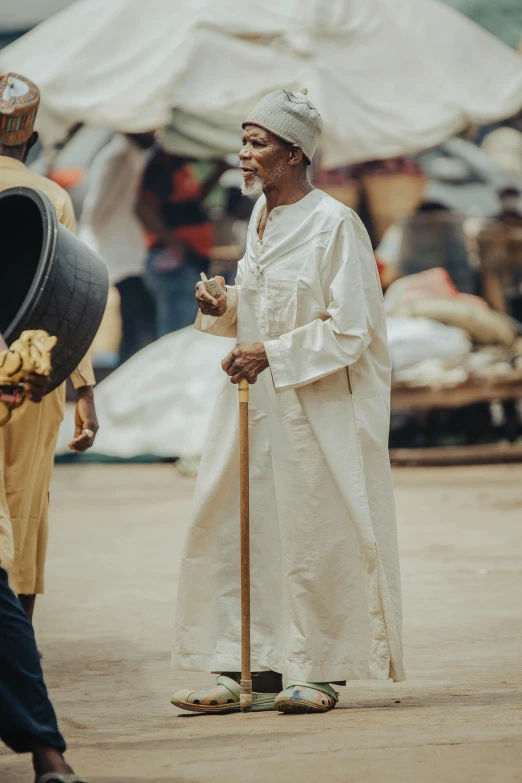 a man dressed in white on top of a street