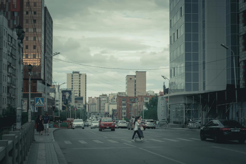 cars and people move down a city street