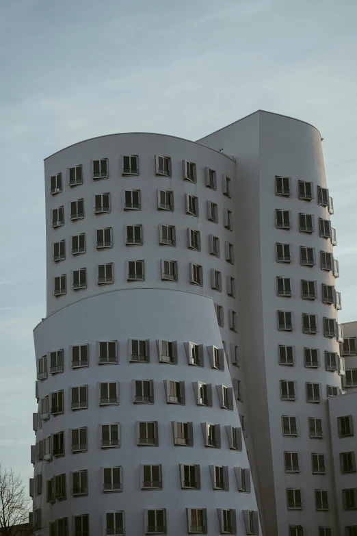 large building with open windows, white color and curved form