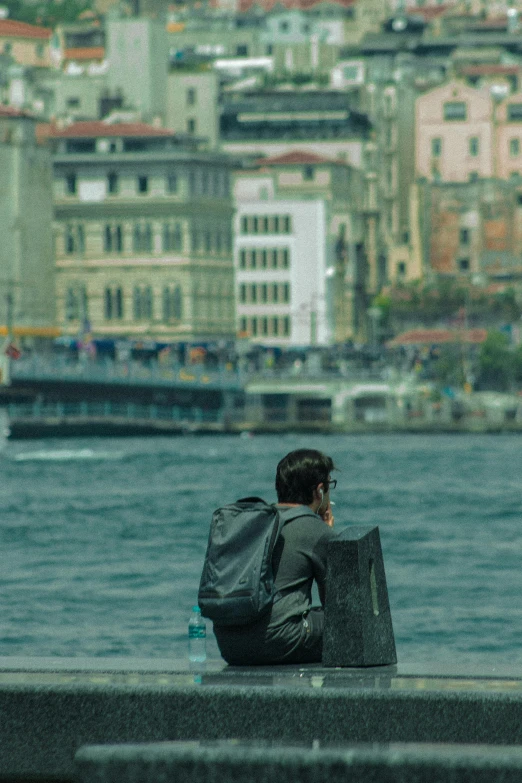 a man sitting on a pier overlooking the city